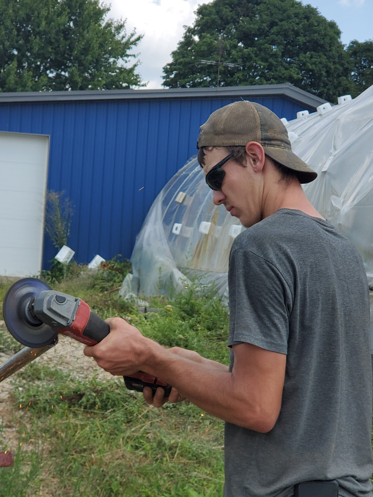 Elisha using a grinder to cut pipe